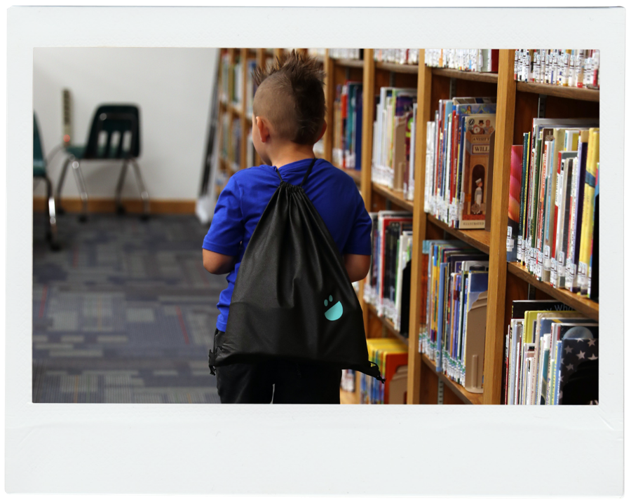 A student with a USANA Kids Eat bag in the school library